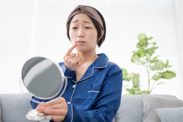 ”口角の高さの違いが気になり悩む女性”